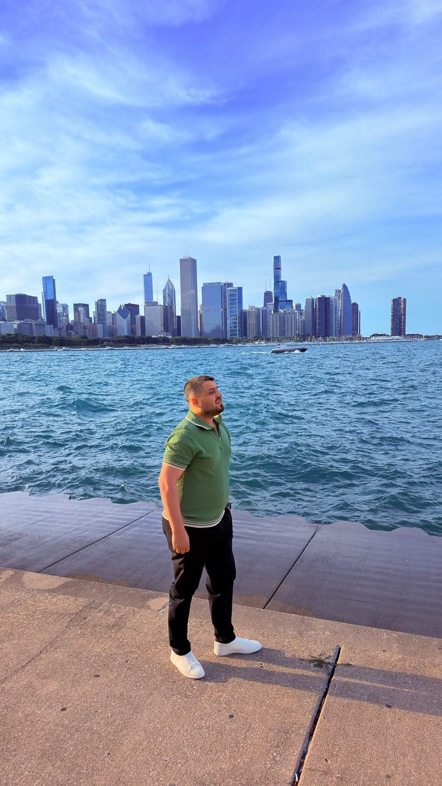 Wali Zuberi standing on the Chicago lakefront with the city skyline behind him