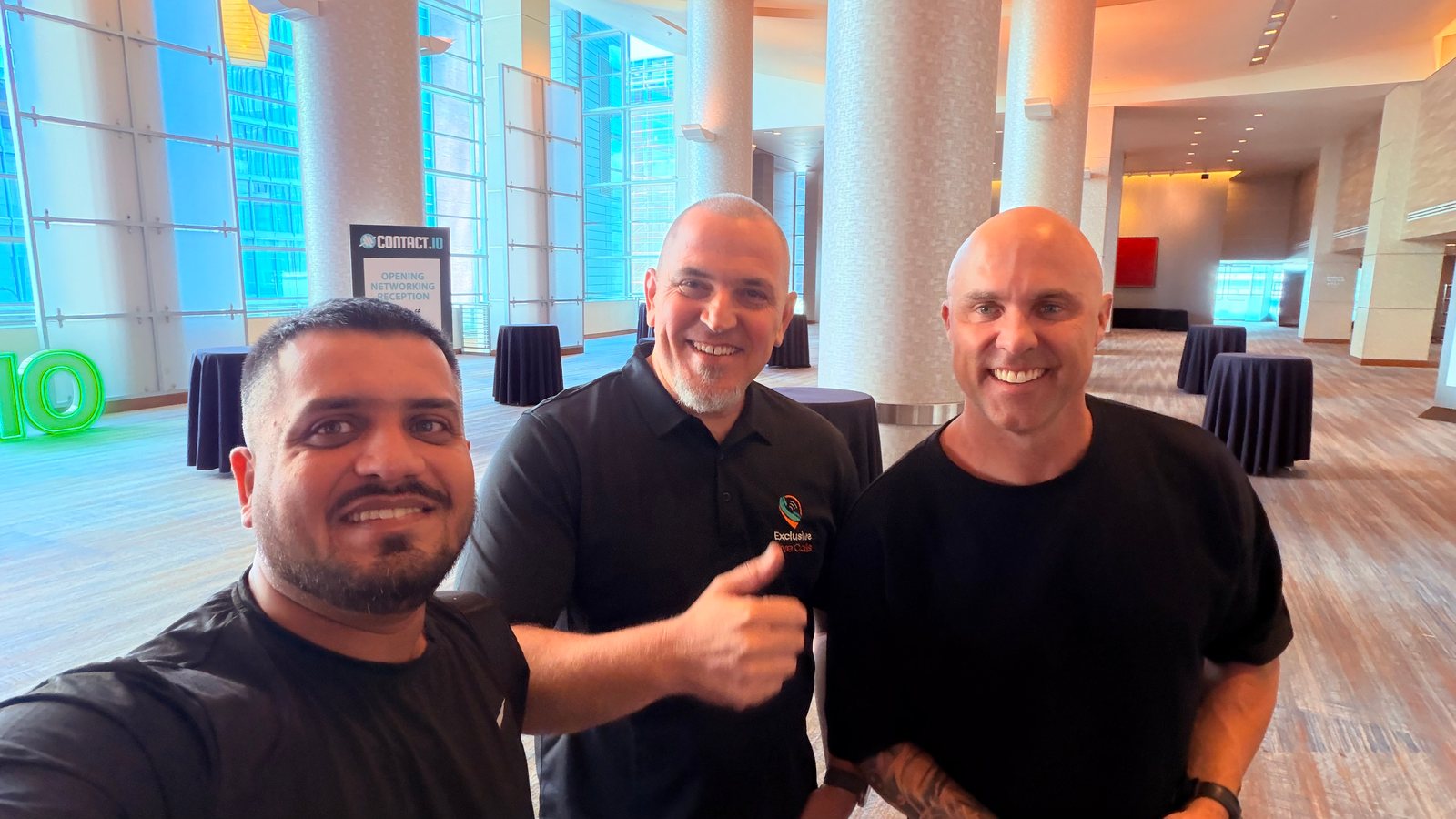 Wali Zuberi taking a group selfie with two attendees at the Contact.io 2026 opening networking reception in Denver
