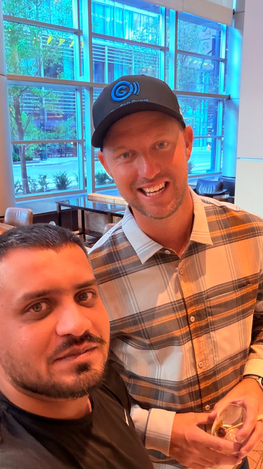 Wali Zuberi taking a selfie with a fellow attendee in a hotel lounge during Contact.io 2026 in Denver